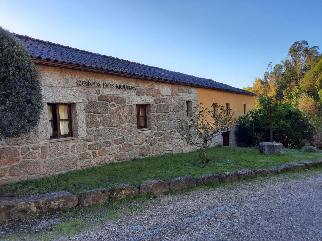 ein Steingebäude mit einem Schild an der Seite in der Unterkunft Quinta dos Mouras in Celorico de Basto