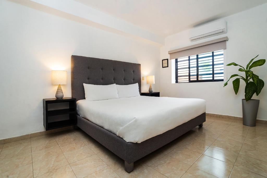 a bedroom with a large white bed and a window at San José Suites Boutique, Linares in Linares