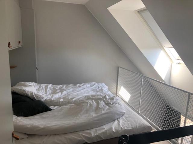 an unmade bed in a white room with at Avanti Apartment Hotel in Stockholm