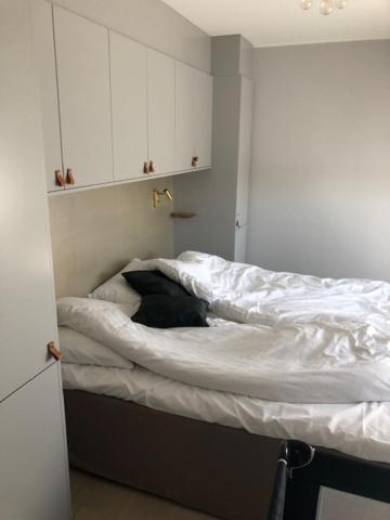 a bedroom with a bed with white sheets at Avanti Apartment Hotel in Stockholm