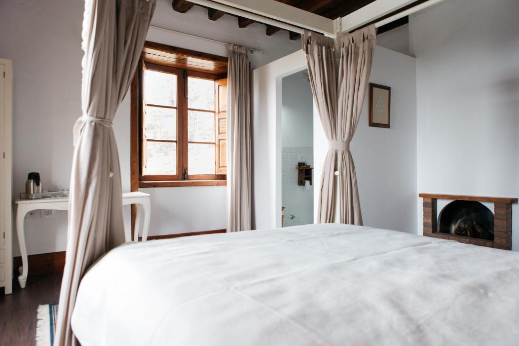 a bedroom with a large white bed and a window at La Casa Inglesa Vilaflor in Vilaflor
