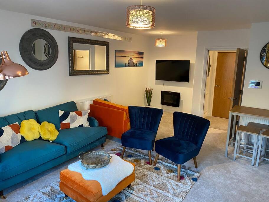 a living room with a blue couch and two chairs at Luxury Modern 1Bed Sea View Apartment in Llandrillo-yn-Rhôs