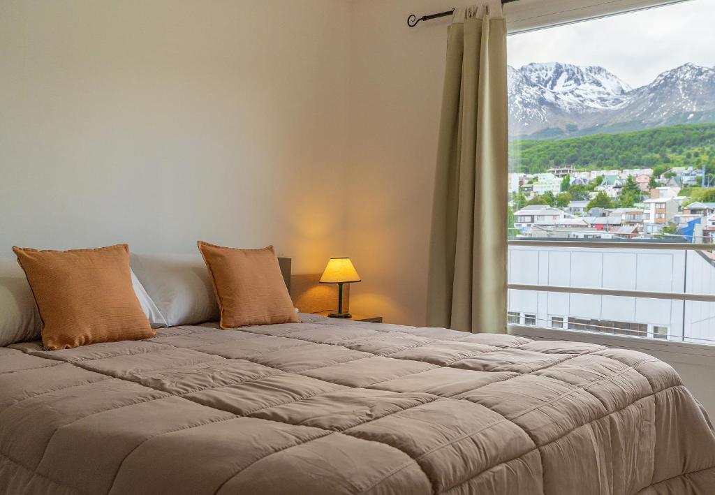 um quarto com uma cama grande e uma janela grande em Happy Guest Apart 56 em Ushuaia