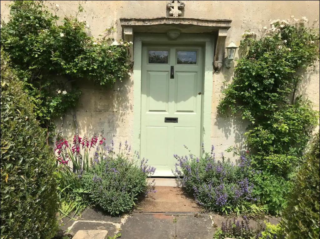 a door of a house with flowers in front of it at Church Cottage in Bath