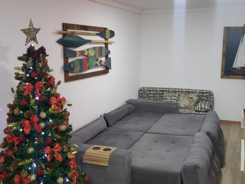 una sala de estar con un árbol de Navidad y un sofá en Apartamento aconchegante à 200m Praia de Piçarras, en Piçarras