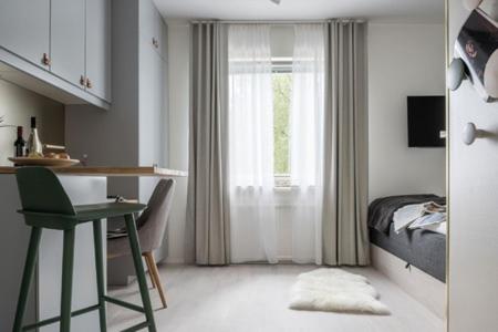 1 dormitorio con escritorio, 1 cama y ventana en Avanti Apartment Hotel en Estocolmo