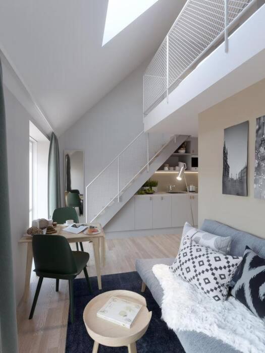 a living room with a blue couch and a staircase at Avanti Apartment Hotel in Stockholm