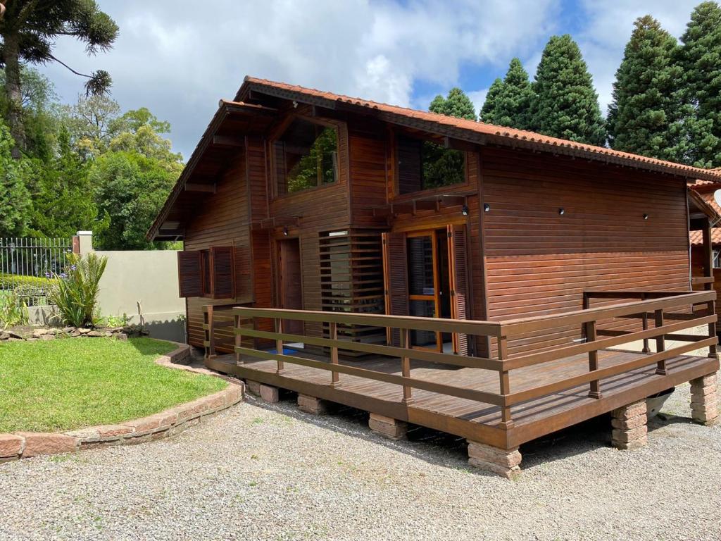 una pequeña casa de madera con un porche en un patio en Chale Morada da Serra, en Canela