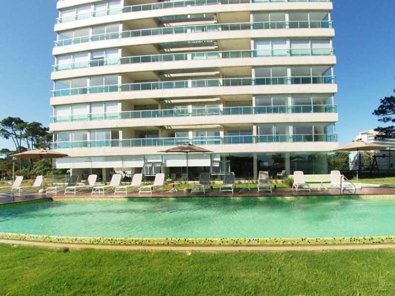 a large building with a swimming pool in front of a building at Gala Vista in Punta del Este