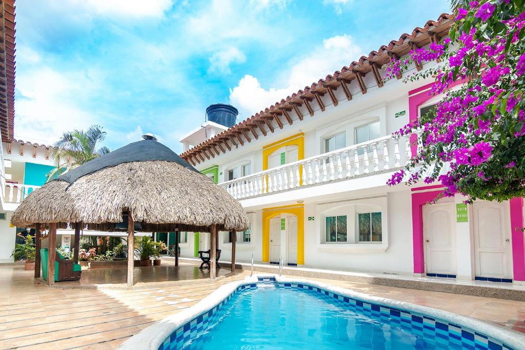 Una villa con piscina y un edificio. en Hotel Casa Grande Riohacha Inn, en Ríohacha
