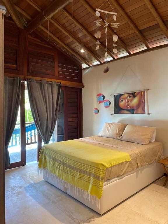 a bedroom with a bed with a painting on the wall at App Sere KiteVillage in Uruau