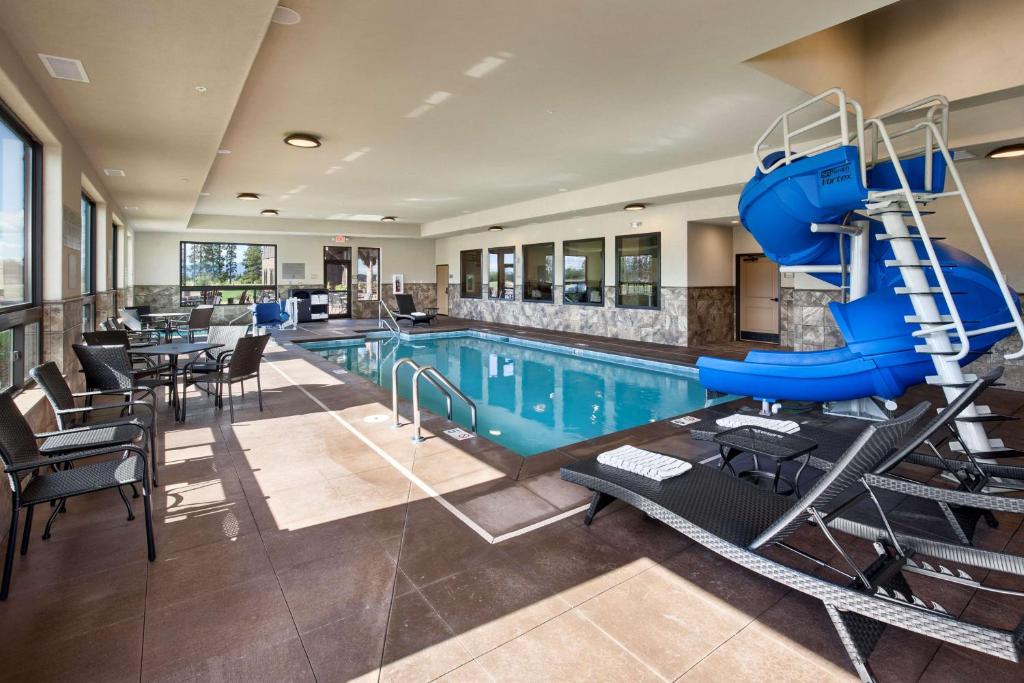 a swimming pool with a slide in a hotel at Glacier International Lodge in Kalispell