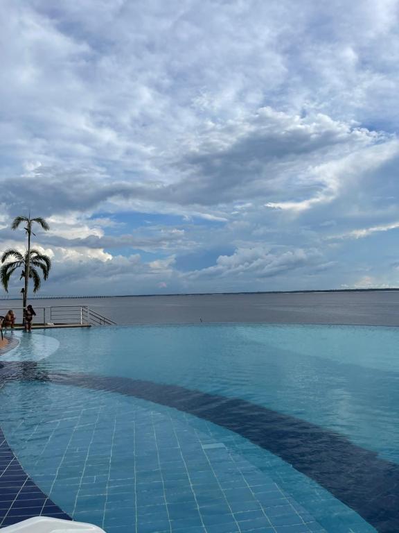 a swimming pool with a view of the ocean at Flat Tropical in Manaus