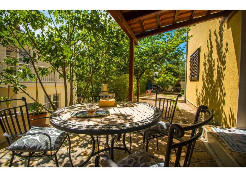 un patio con mesa y sillas en un porche en Apartments Mana - 250 m from sea, en Split