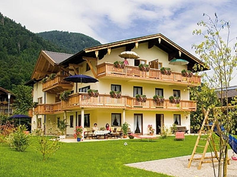ein großes Haus mit Menschen auf dem Balkon in der Unterkunft Ferienwohnungen am Westernberg in Ruhpolding