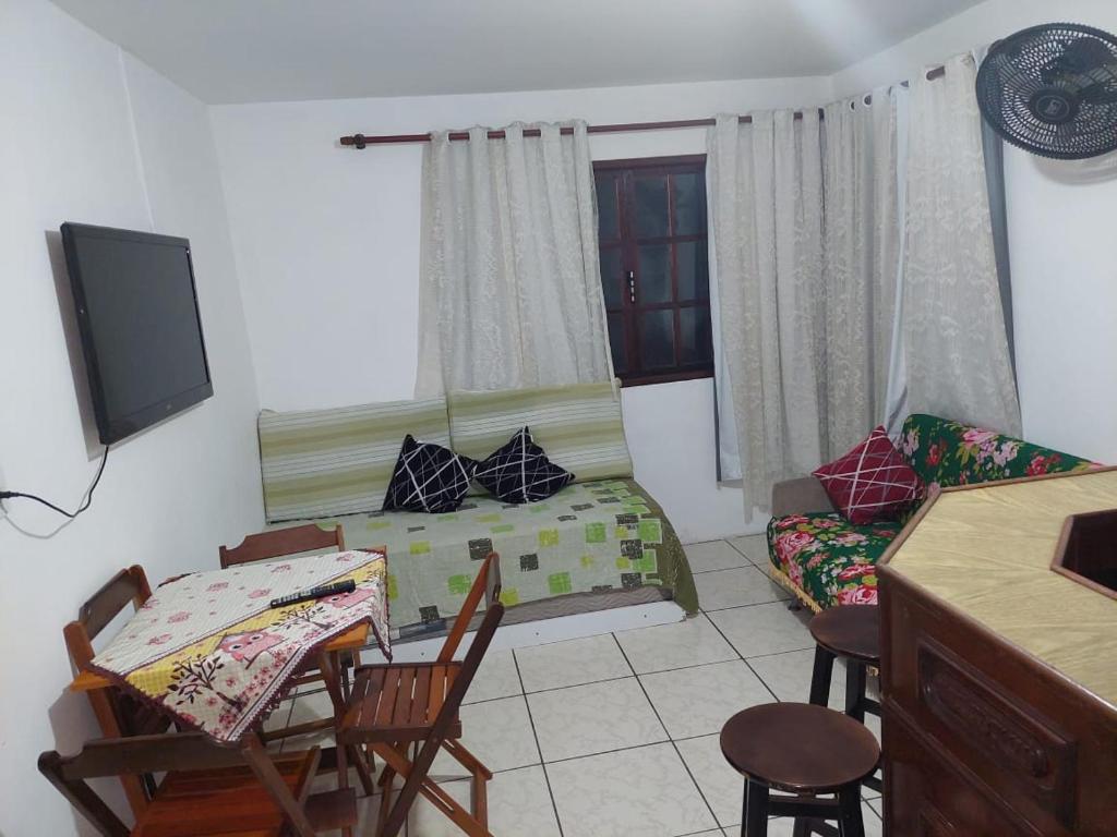 ein Wohnzimmer mit einem Sofa, einem Tisch und Stühlen in der Unterkunft Centro De Arraial Do Cabo in Arraial do Cabo