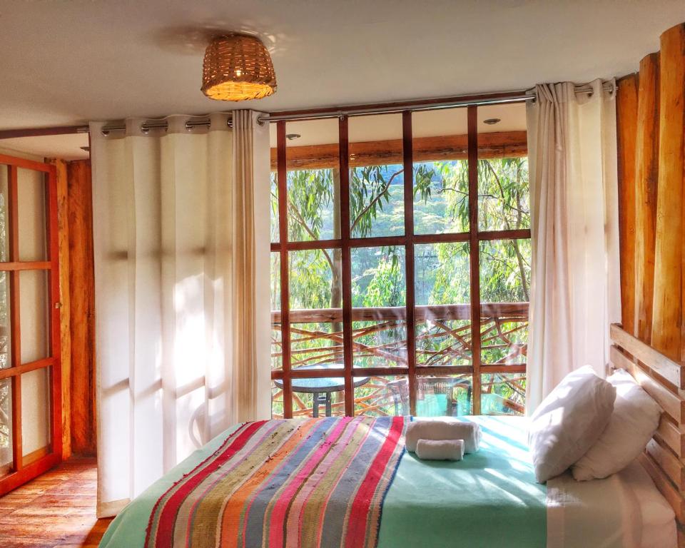 
a bedroom with a bed and a window at Eco Quechua Lodge in Santa Teresa
