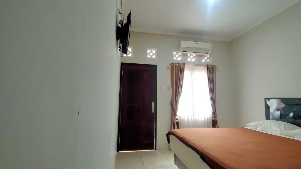 a bedroom with a bed and a window at Aqsa Guest House Ciamis Syariah in Ciamis