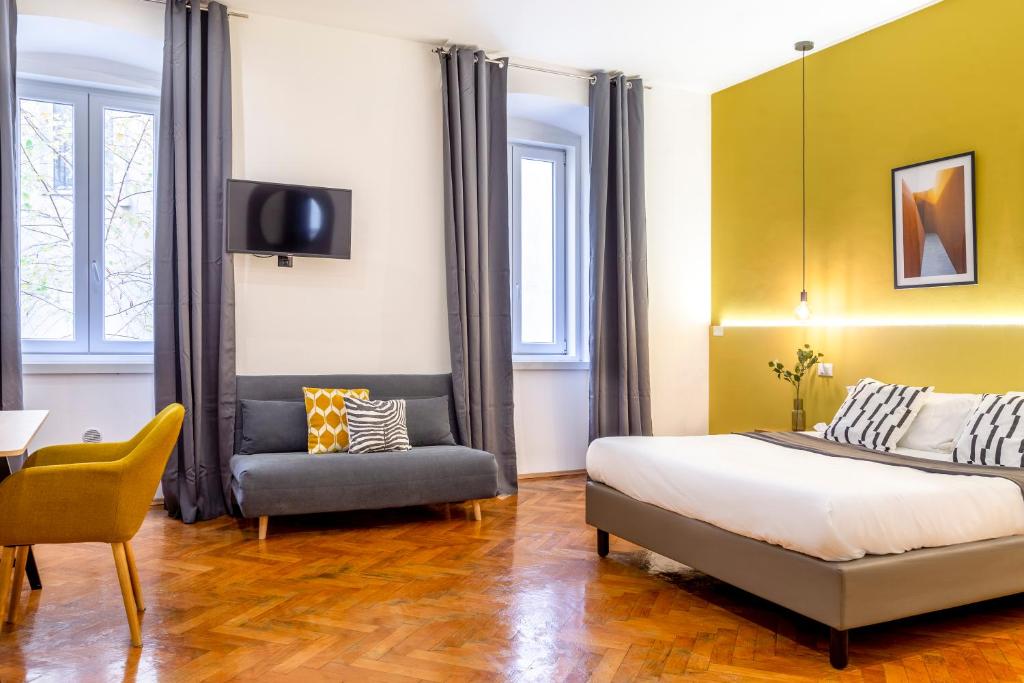 - une chambre avec un lit, une télévision et une chaise dans l'établissement Elegante appartamento vicino alla stazione - Gold, à Trieste