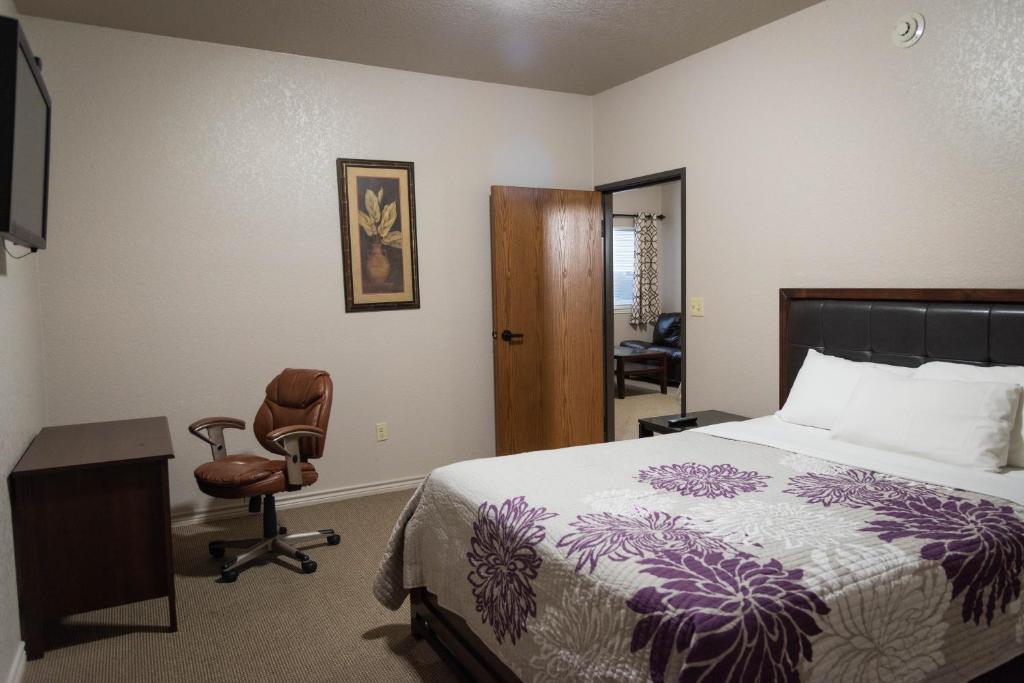 a bedroom with a bed and a desk and a chair at Premium Inn and Suites in Killeen