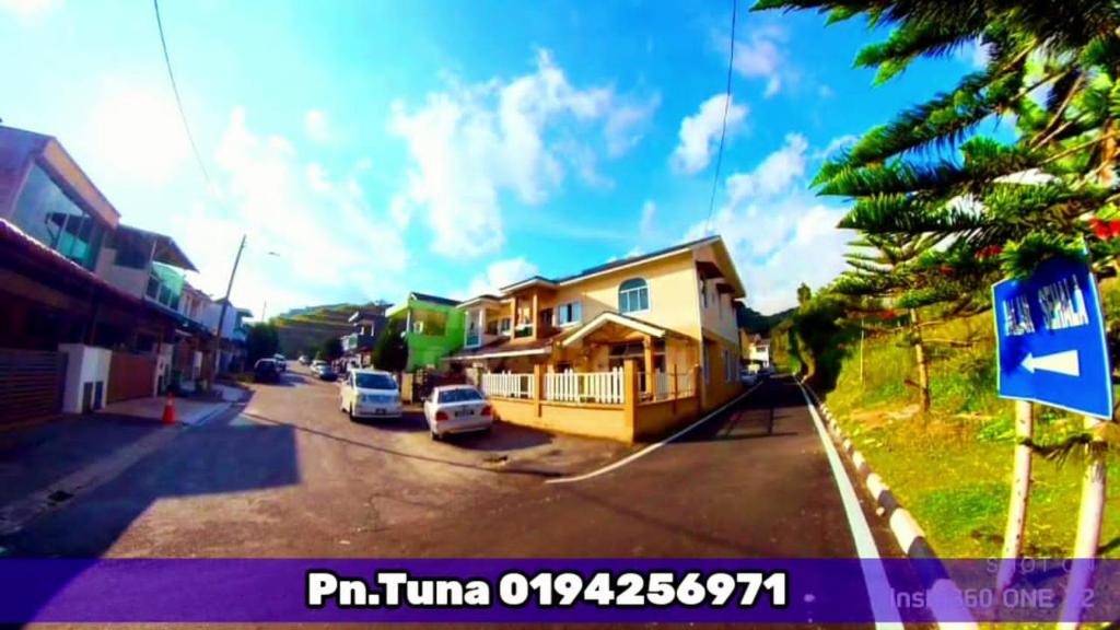 una vista de una calle con una casa y un letrero de la calle en Tuna Cameron Homstay, en Brinchang