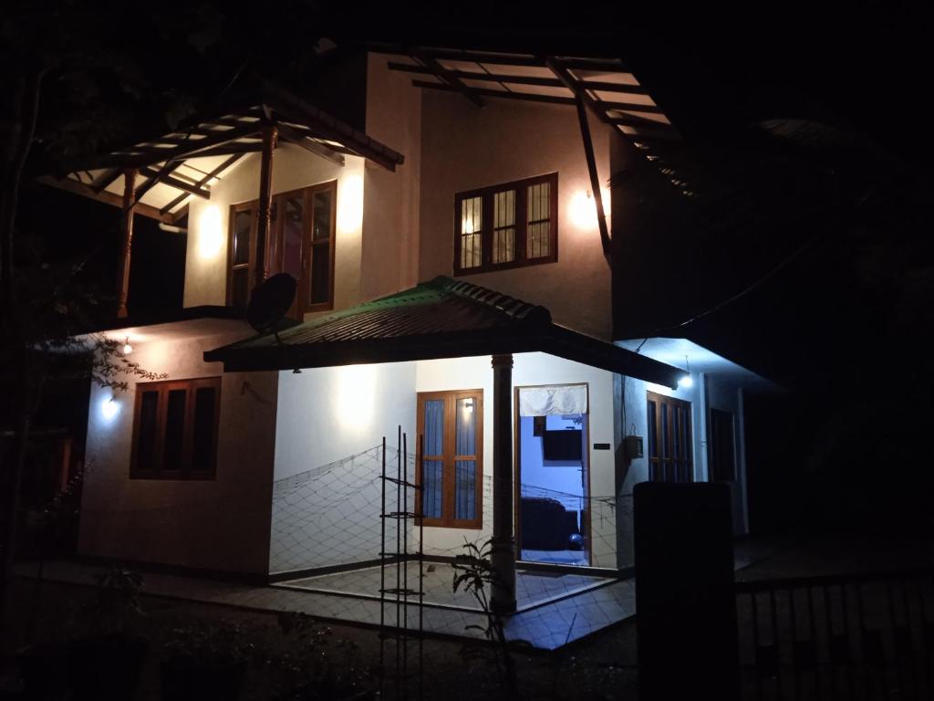 una pequeña casa con un paraguas en la oscuridad en G&D Home Stay en Dodanduwa