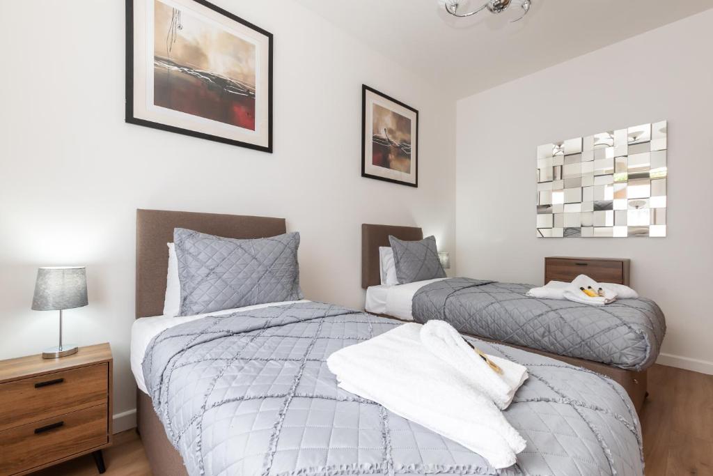 a bedroom with two beds and a night stand at Silver Moon Silver Service Apartments Freeparking in Southampton