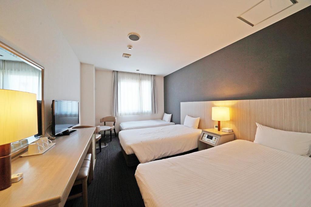 東京にあるチサン ホテル 蒲田のベッド2台とテレビがあるホテルの部屋