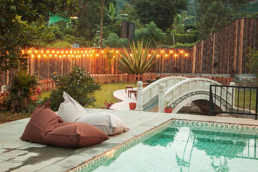 a pool with pillows on a patio next to a fence at Villa Rone By The Villas 100 in Bogor