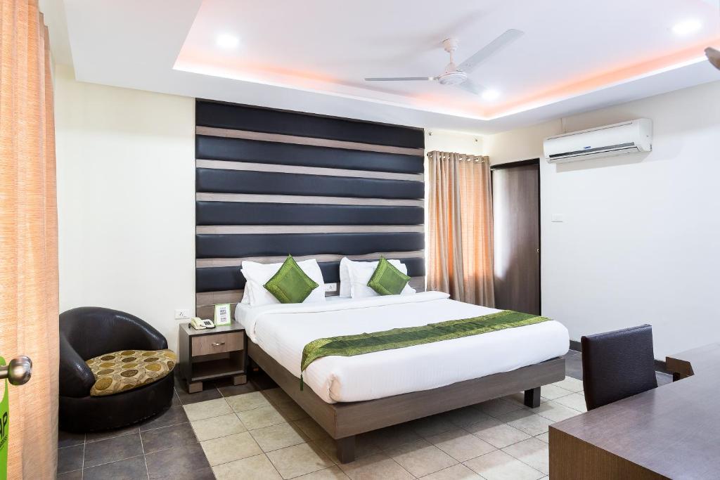 a hotel room with a bed and a chair at Treebo Trend Fort Club in Hyderabad