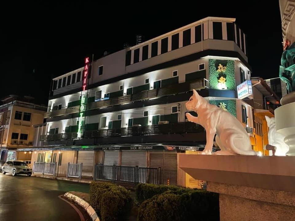 una estatua de un gato sentado en la parte superior de un edificio en Kapit Hotel, en Kuching