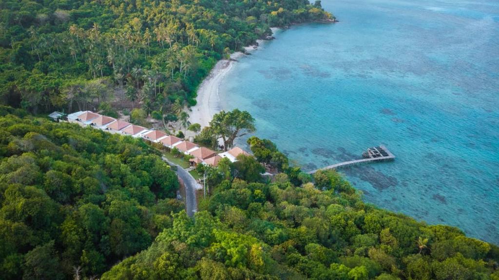 Legon Waru Cottage في كاريمونجاوا: اطلالة جوية على منزل في جزيرة في المحيط