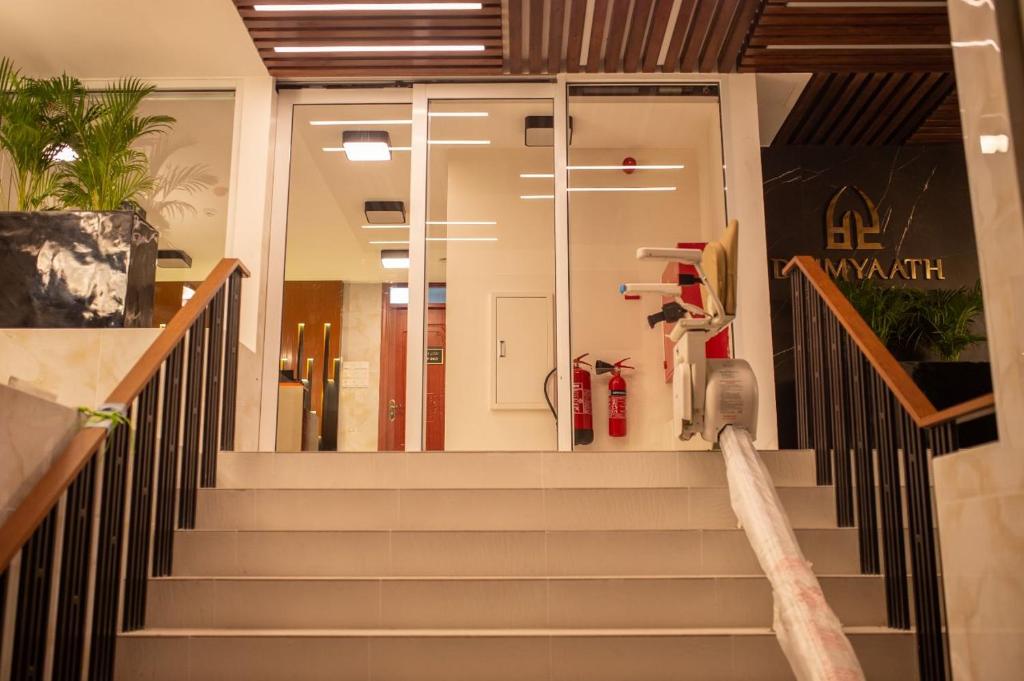 a staircase in a building with a glass entry door at Dhimyaath Stay in Male City