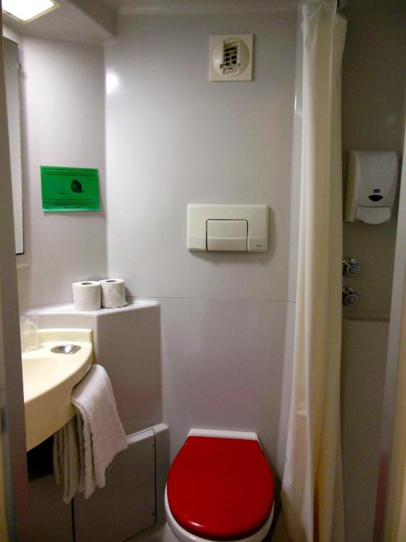 a bathroom with a red toilet and a sink at Mister Bed Chambray Les Tours in Chambray-lès-Tours