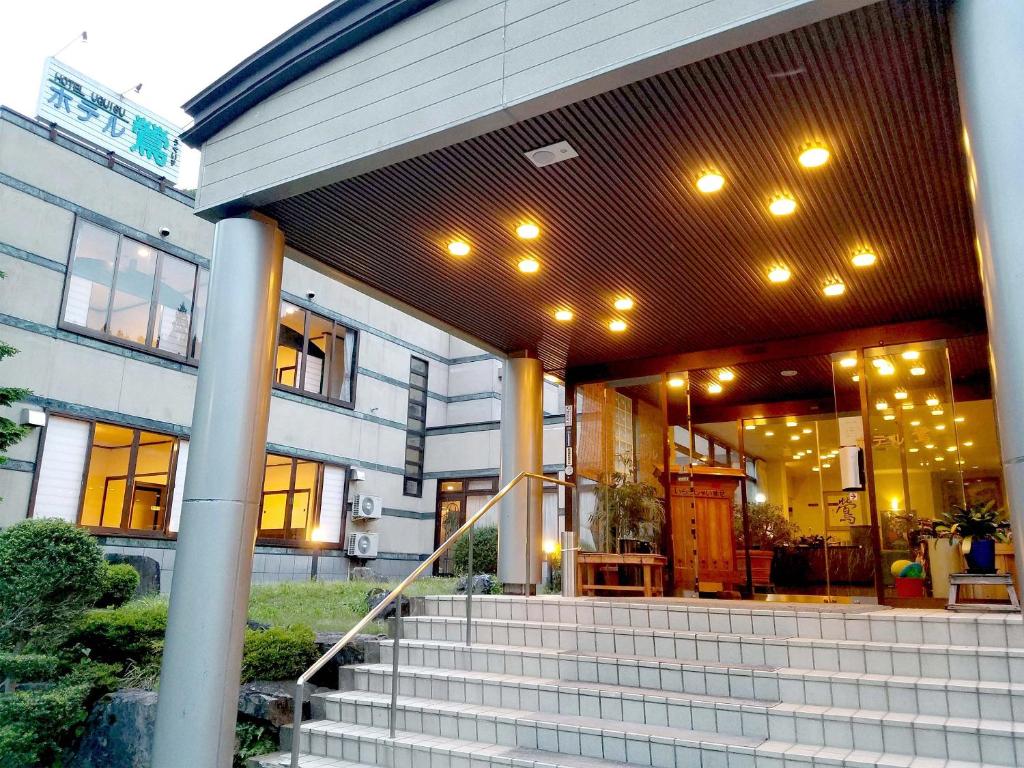 un edificio con escaleras delante de un edificio con luces en Hotel Uguisu, en Shizukuishi