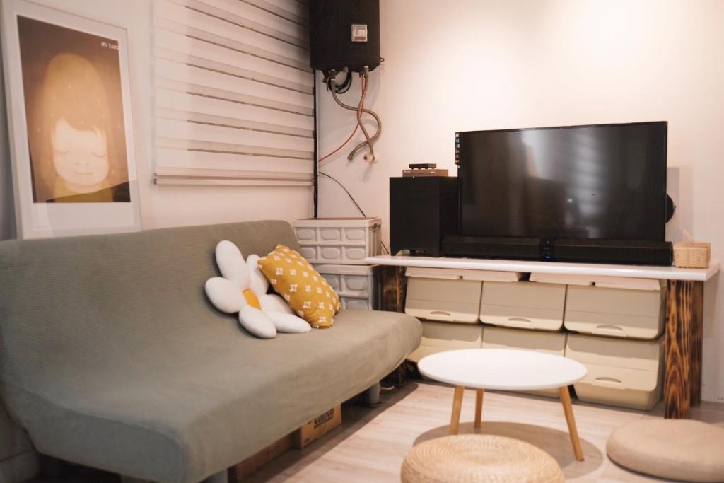 a living room with a couch and a flat screen tv at Co Diving Hostel in Xiaoliuqiu