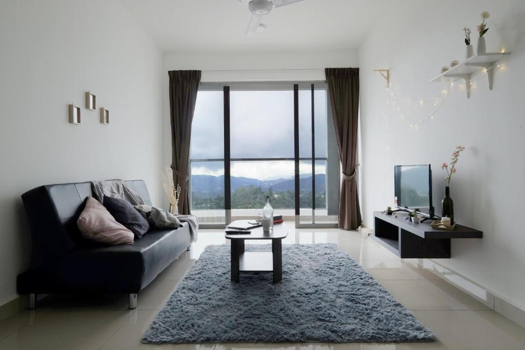 a living room with a black couch and a table at PLAY at Palas Horizon @ Kea Farm in Cameron Highlands