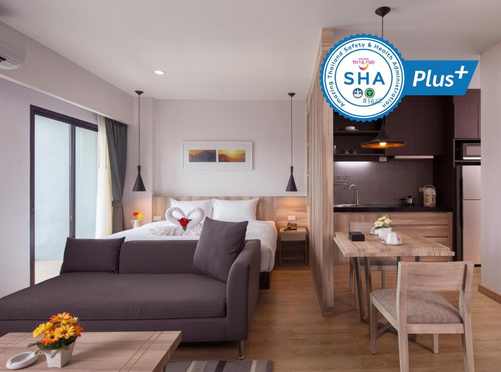 Si Maha Phot的住宿－運河304公寓式酒店，酒店客房配有床、沙发和桌子。