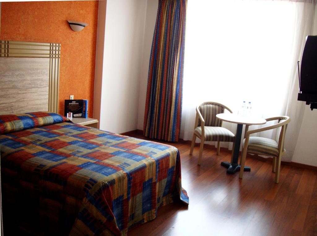 Postel nebo postele na pokoji v ubytování Hotel Cervantes