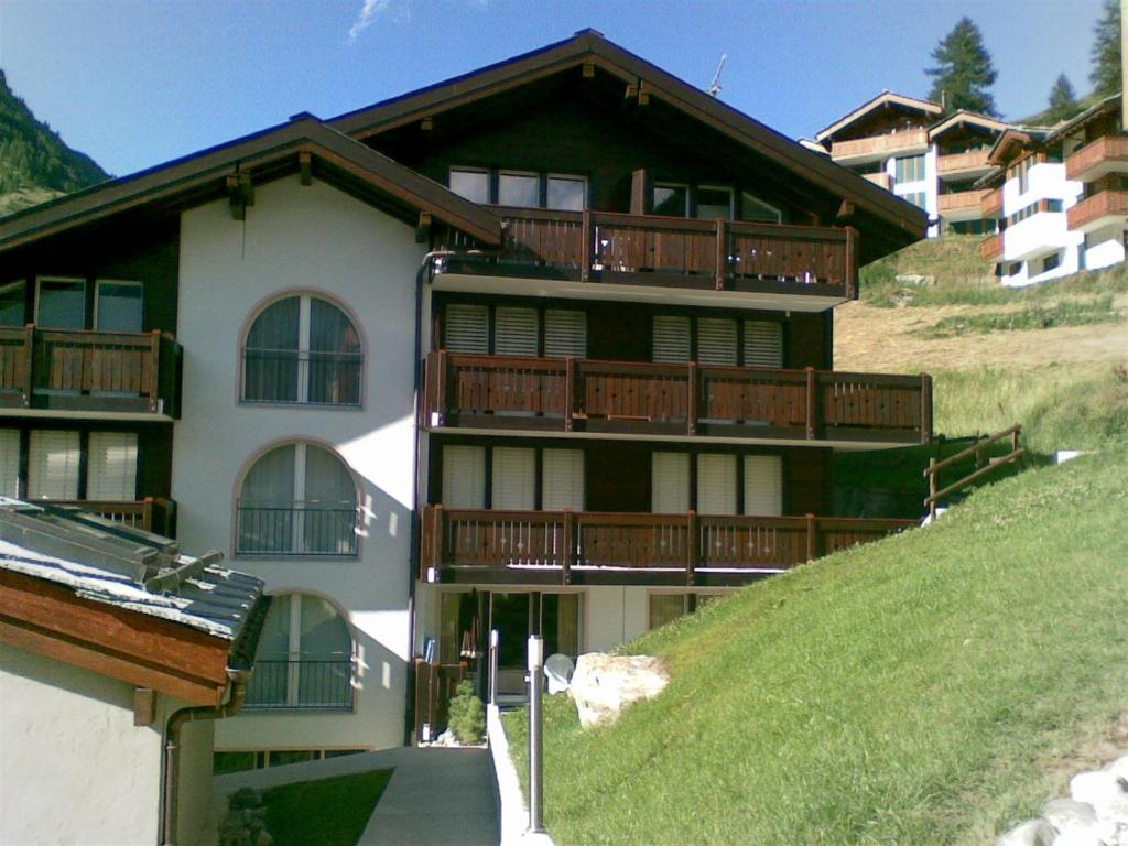 budynek z balkonami na zboczu wzgórza w obiekcie Casa Collinetta w mieście Zermatt