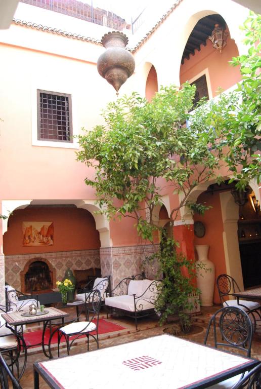 an outdoor patio with tables and chairs and a fireplace at riad Cala Medina in Marrakesh