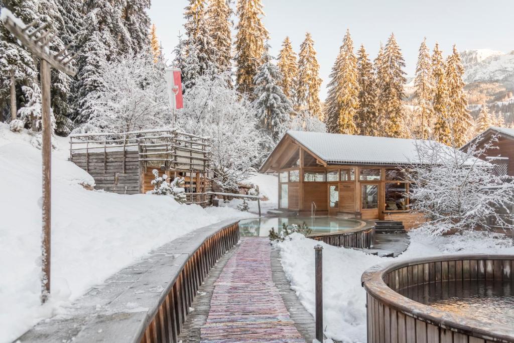 uma cabana de madeira na neve em Hotel Bad Schörgau em Sarentino