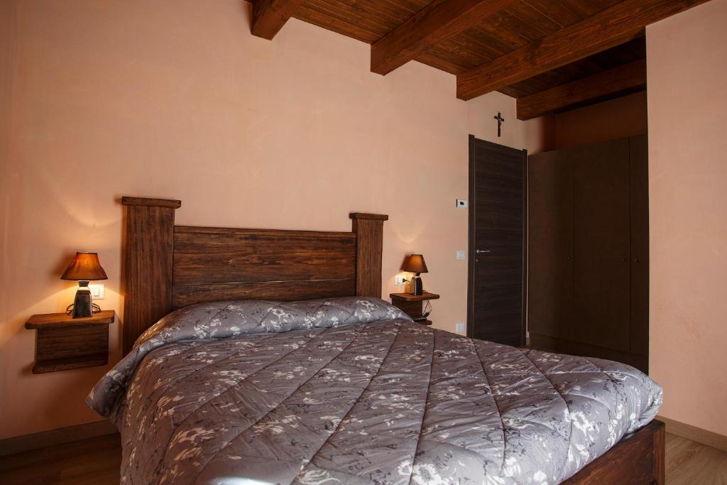 sypialnia z dużym łóżkiem i 2 lampami w obiekcie Circolo Operaio Acli Colloro w mieście Alpe Lagarasc