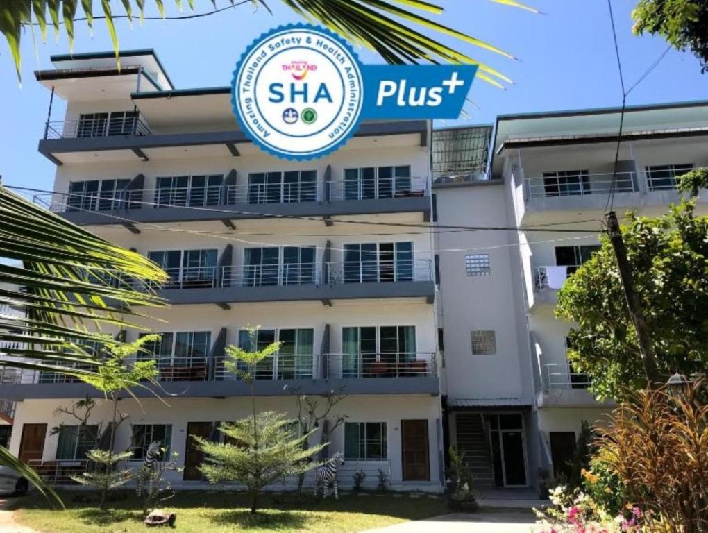 um edifício com uma placa que diz shka plus em Kasemsuk Guesthouse SHA Extra plus em Praia de Karon