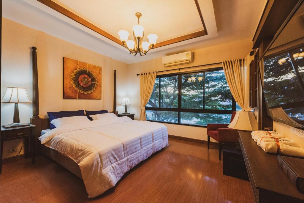 ein Schlafzimmer mit einem Bett und einem großen Fenster in der Unterkunft AMAZ Bed & Cafe in Ban Pa Faek