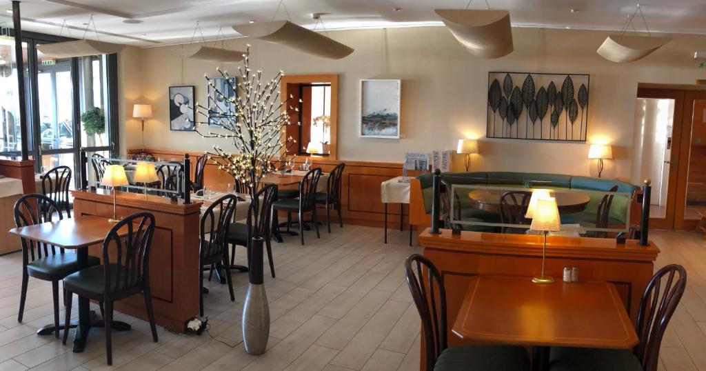 a dining room with tables and chairs in a restaurant at Hôtel du Port in Lausanne