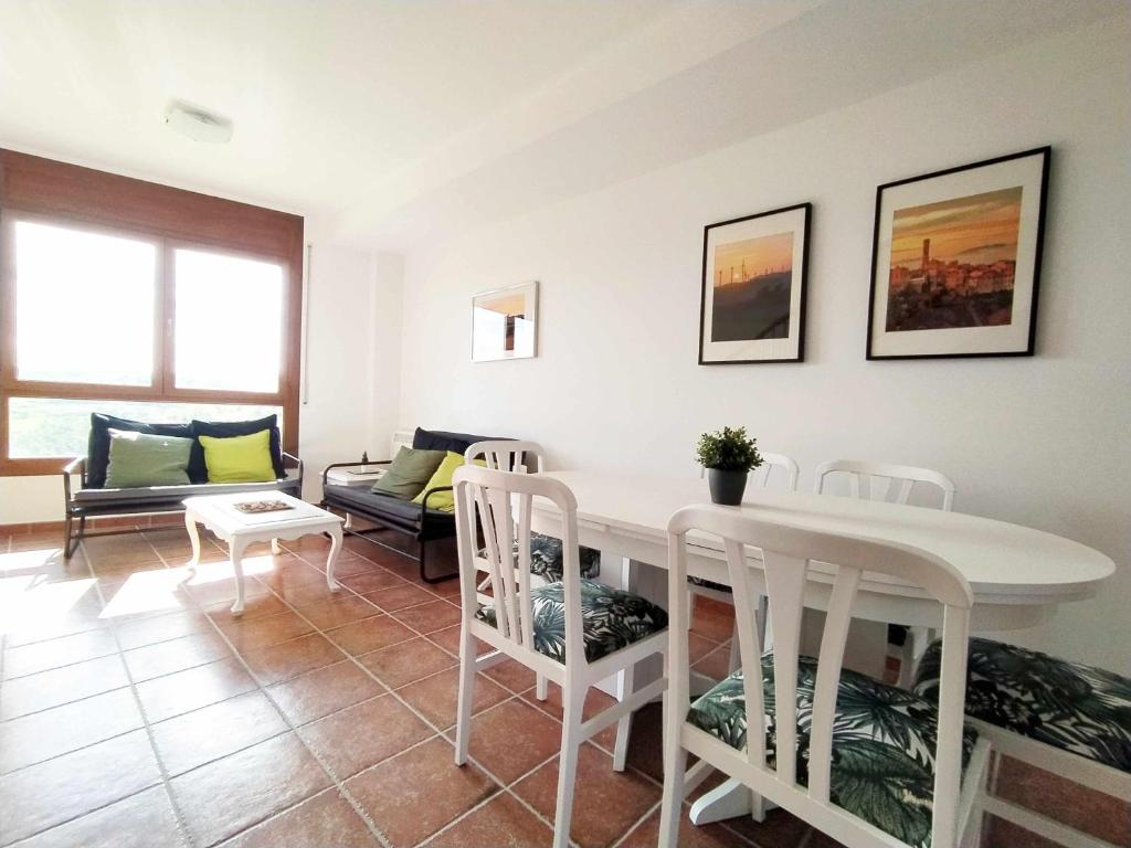 ein Wohnzimmer mit einem weißen Tisch und Stühlen in der Unterkunft Casa BellMón vive el Astroturismo en Belltall in Belltal