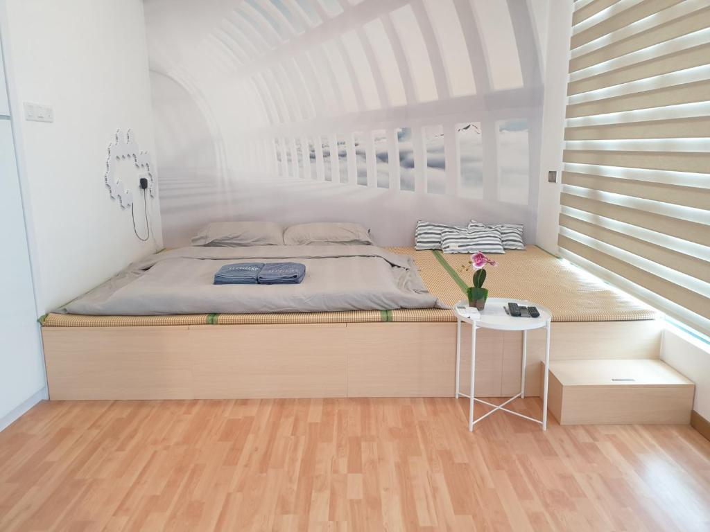 Un dormitorio con una cama y una mesa pequeña. en Best moments, en Kuantan