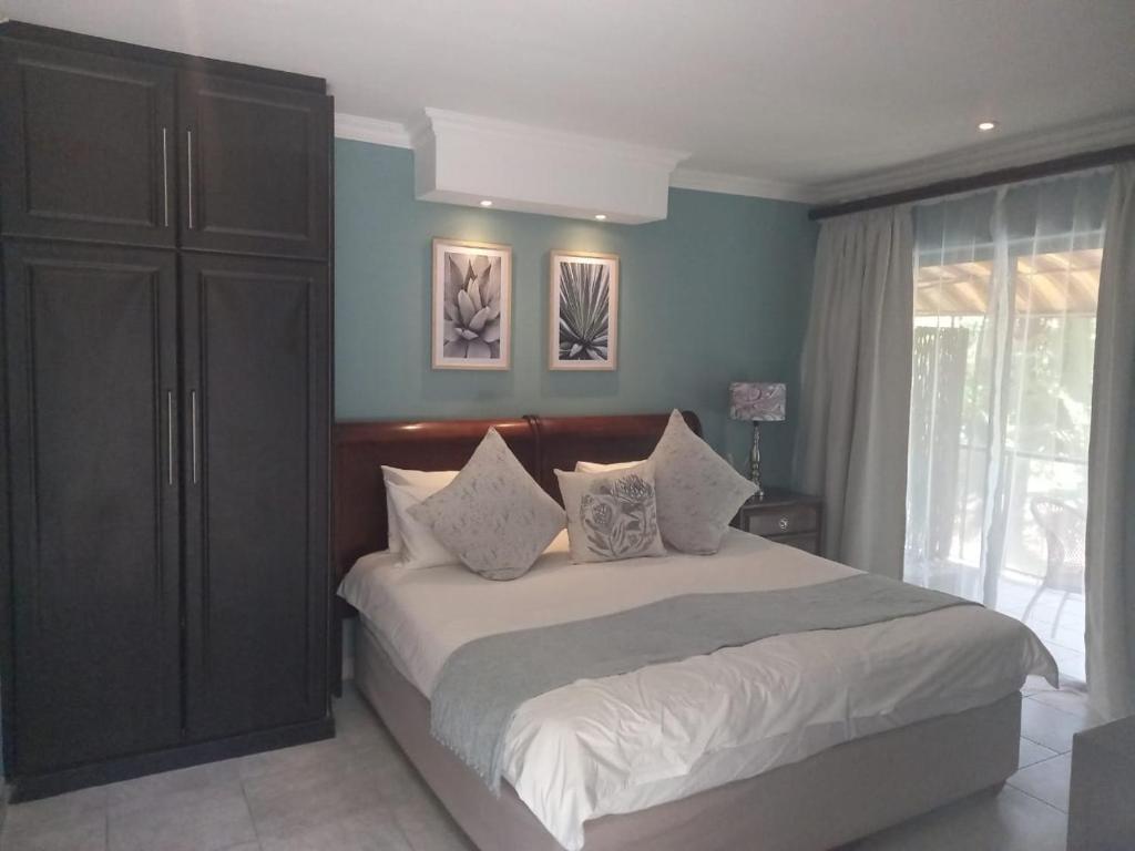 a bedroom with a large bed with blue walls at Fairways Hotel in Ballito