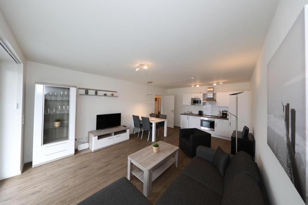 uma sala de estar com um sofá e uma mesa em Ferienwohnung Quartier HOHE GEEST 12 em Cuxhaven